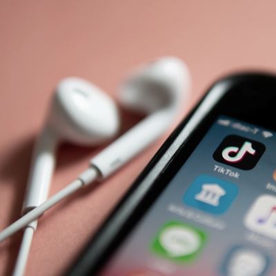 Illustrasjon av mobiltelefon med TikTok-appen på skjermen