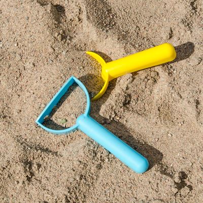 Illustrasjon av spade og andre leker i en sandkasse